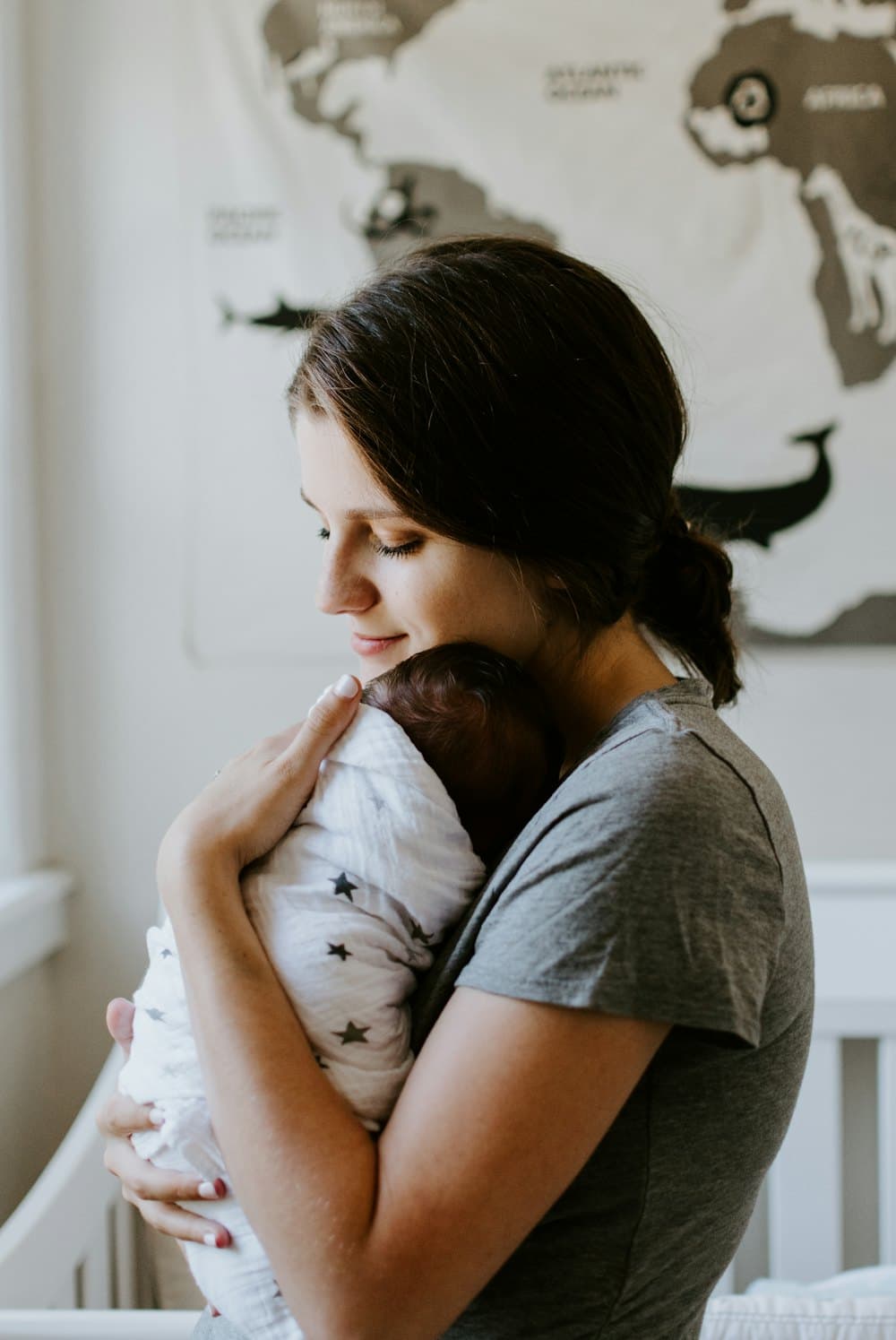 A parent holding their newborn against their chest